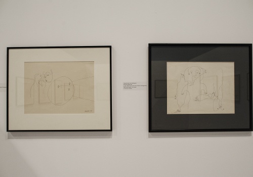 Zdjęcie, dokumentacja wystawy prac Franciszki Themerson pod tytułem „Linie życia”. Na białej ścianie Sali Wystawienniczej prezentowane są dwie ilustracje artystki.