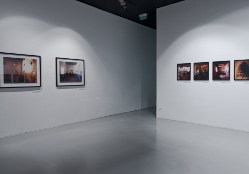 Zdjęcie, wnętrze pustej Sali Wystawienniczej. Na ścianach prezentowane są fotografie Jerzego Wierzbickiego.