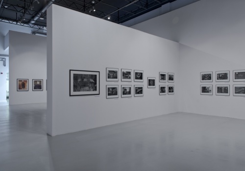 Zdjęcie, wnętrze Sali Wystawienniczej. Na białych ścianach prezentowane są liczne fotografie Jerzego Wierzbickiego.