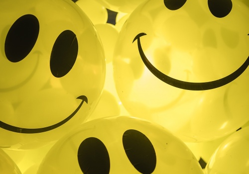 Fotografia przedstawiająca instalację artystyczną w postaci podświetlonych, żółtych balonów z nadrukiem uśmiechniętego emotikonu, wypełniających wnętrze galerii LKW. Instalacja „Smile, please” autorstwa Magdaleny i Ksawerego Kirklewskich.