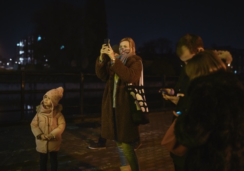 Fotografia przedstawiająca gości galerii LKW wraz z kuratorką Anną Szynwelską podczas wernisażu wydarzenia „Smile, please”.