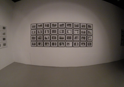Sala wystawiennicza z licznymi pracami autorstwa Adrei Mastrovito ukazujące kadry z filmów rozmieszczone w czterech rzędach i dziewięciu kolumnach.