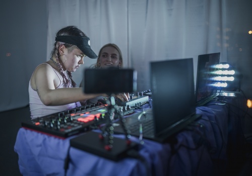 Kadr na dwie artystki przy sprzęcie DJ’skim wewnątrz Galerii LKW.