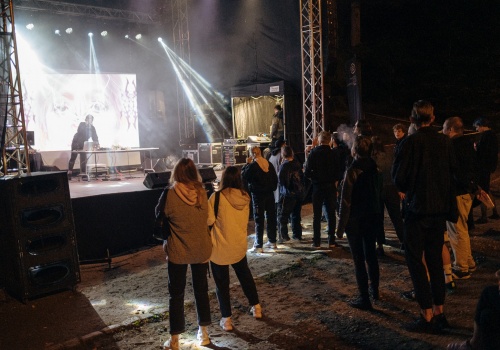 Kadr na oświtloną scenę Teatru Leśnego, wraz z bawiącą się widownią podczas wydarzenia INPROGRESS 2021.