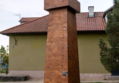 Fotografia przedstawiająca schematycznie wykonany obiekt z drewna, przypominający latarnię morską, autorstwa Pawła Błęckiego. Fotografia wykonana podczas wydarzenia „PRZYSTAŃ. PAWEŁ BŁĘCKI”.